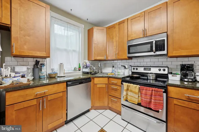 a kitchen with stainless steel appliances granite countertop wooden cabinets a sink and a stove