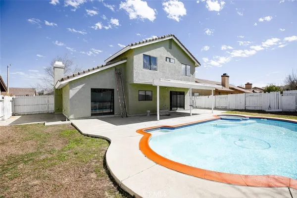 a view of a house with swimming pool and a yard