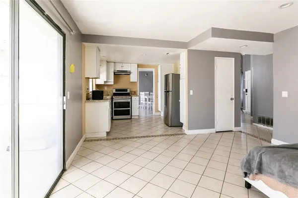 a view of a kitchen with kitchen island granite countertop wooden floor and a refrigerator