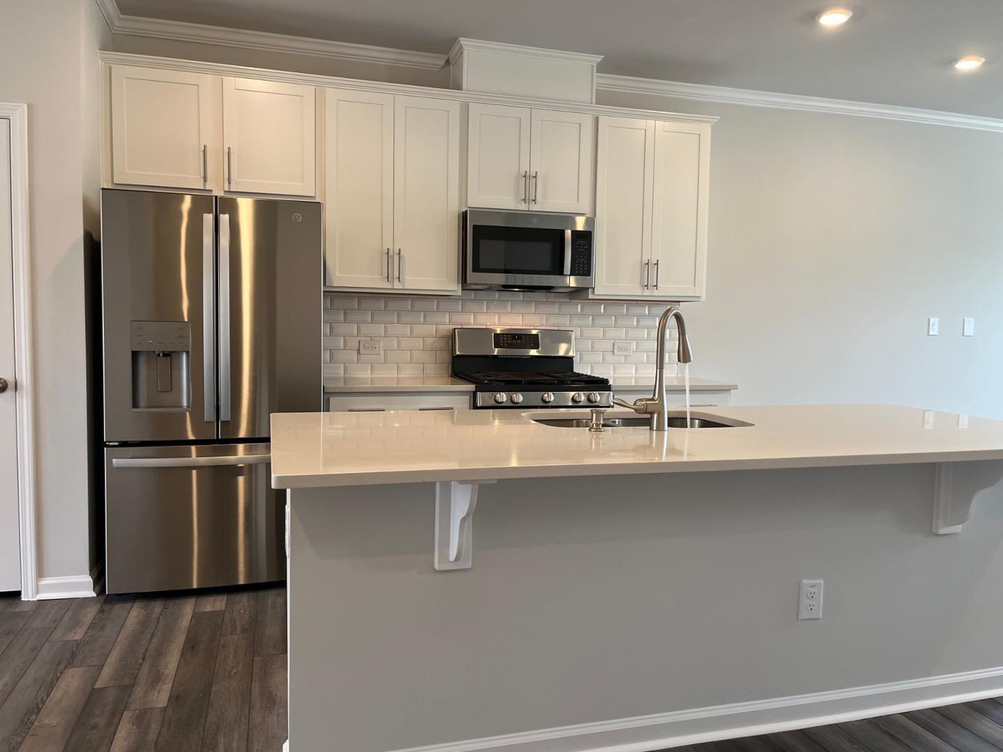 1705 Barrett Run Trail Apex, NC 27502 - Photo 5 of 24 a kitchen with stainless steel appliances a refrigerator a sink and white cabinets