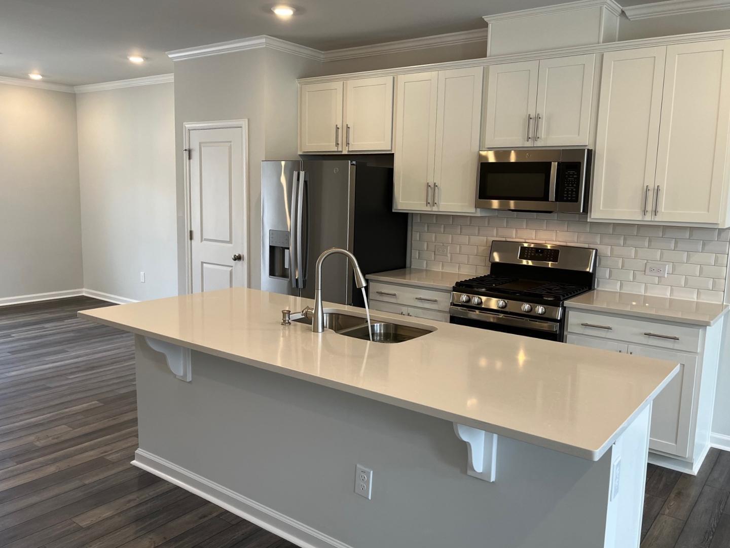 1705 Barrett Run Trail Apex, NC 27502 - Photo 7 of 24 a kitchen with stainless steel appliances a sink a stove a microwave and refrigerator