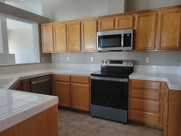 a kitchen with stainless steel appliances granite countertop white cabinets and a stove top oven