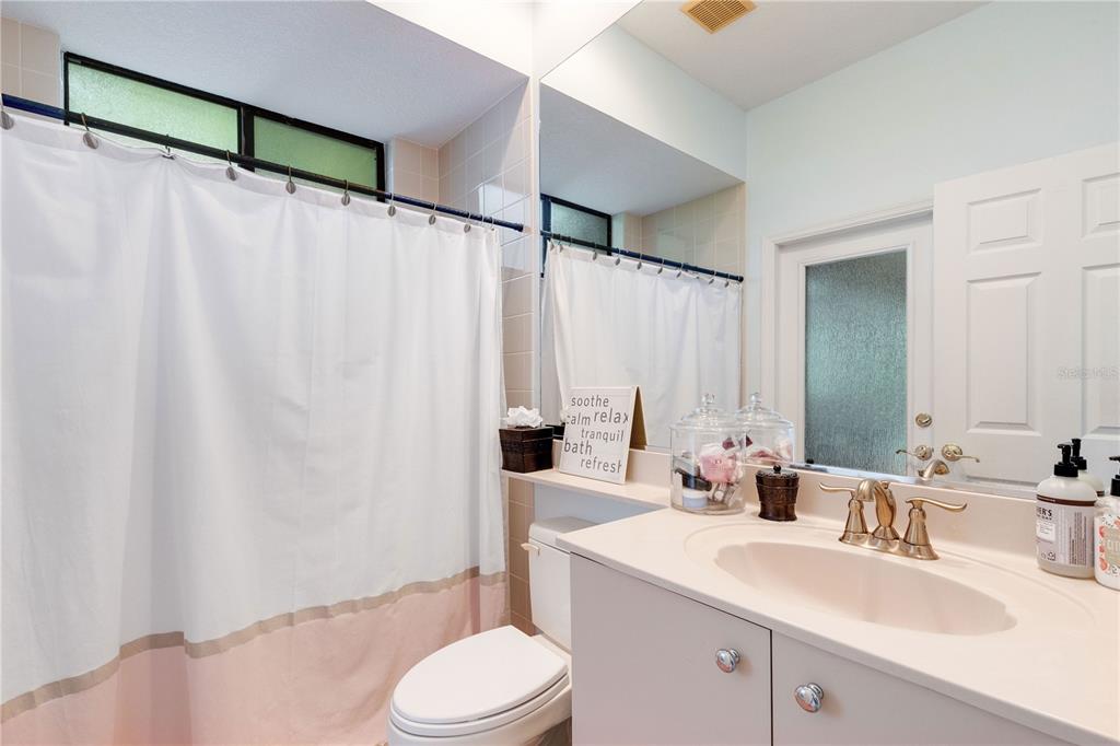 6828 Honeysuckle Trail Lakewood Ranch, FL 34202 - Photo 33 of 36 a bathroom with a sink a toilet and shower curtain