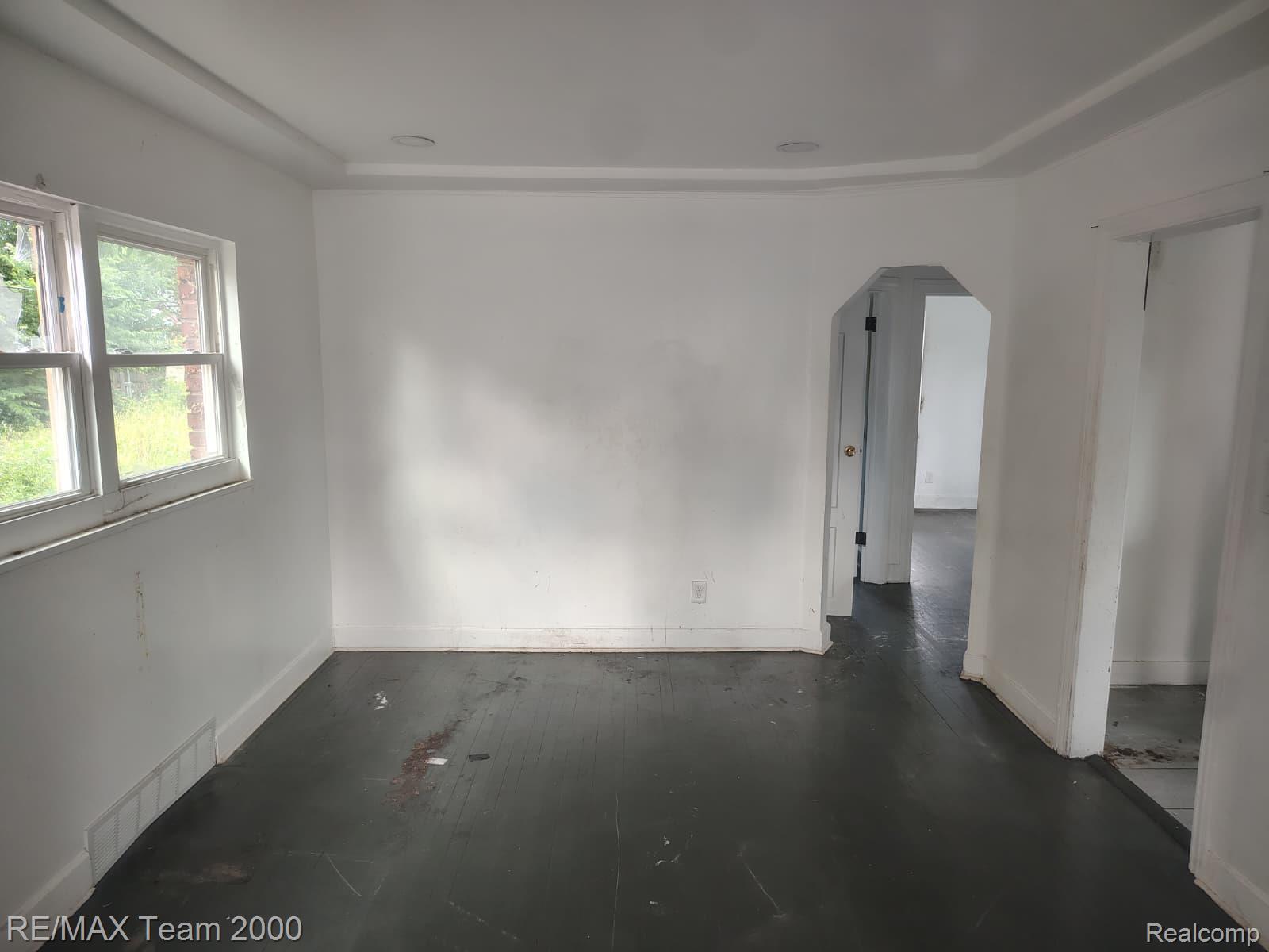 8860 Appoline Street Detroit, MI 48228 - Photo 11 of 45 Spacious room with dark wood-finish flooring, white walls, and a multi-pane window