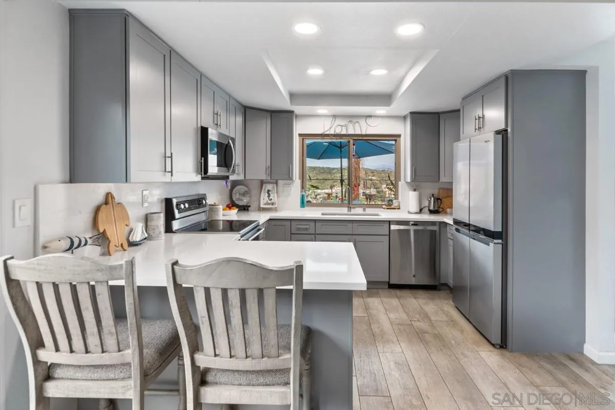 10952 Avenida Roberta Spring Valley, CA 91978 - Photo 11 of 35 a kitchen with kitchen island granite countertop a sink stove and refrigerator