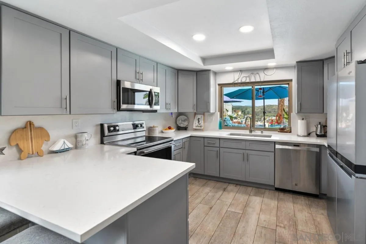 10952 Avenida Roberta Spring Valley, CA 91978 - Photo 10 of 35 a kitchen with stainless steel appliances a stove a sink a microwave a refrigerator and cabinets