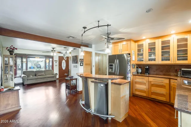 a kitchen with stainless steel appliances granite countertop a refrigerator a stove and a wooden floors