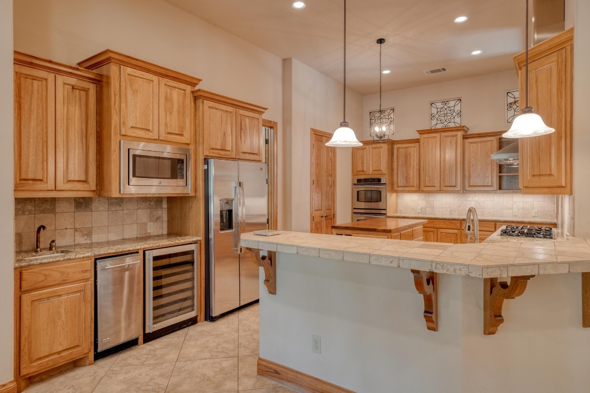 205 Flint Ridge Trail Georgetown, TX 78628 - Photo 13 of 40 a kitchen with stainless steel appliances granite countertop a sink a stove and a refrigerator