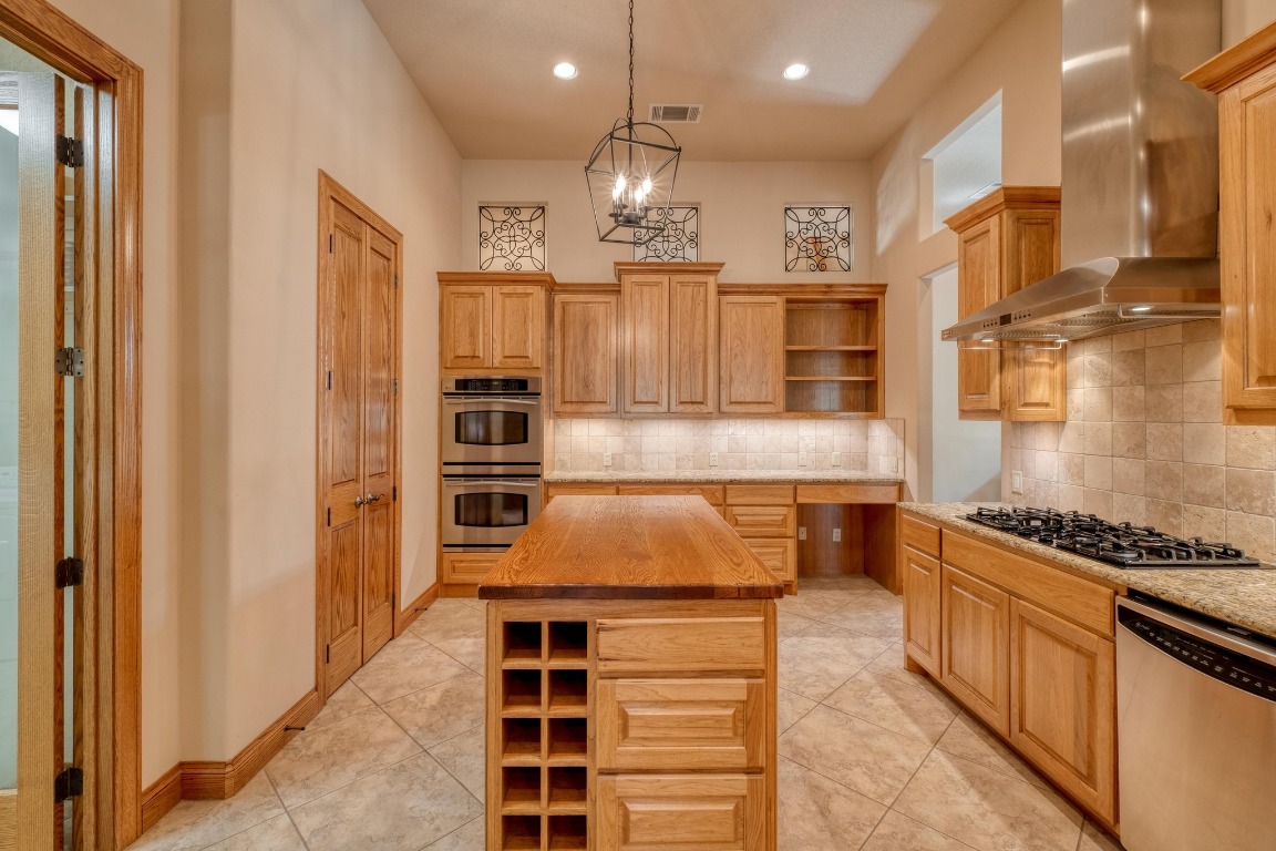 205 Flint Ridge Trail Georgetown, TX 78628 - Photo 14 of 40 a kitchen with kitchen island granite countertop a stove and a refrigerator