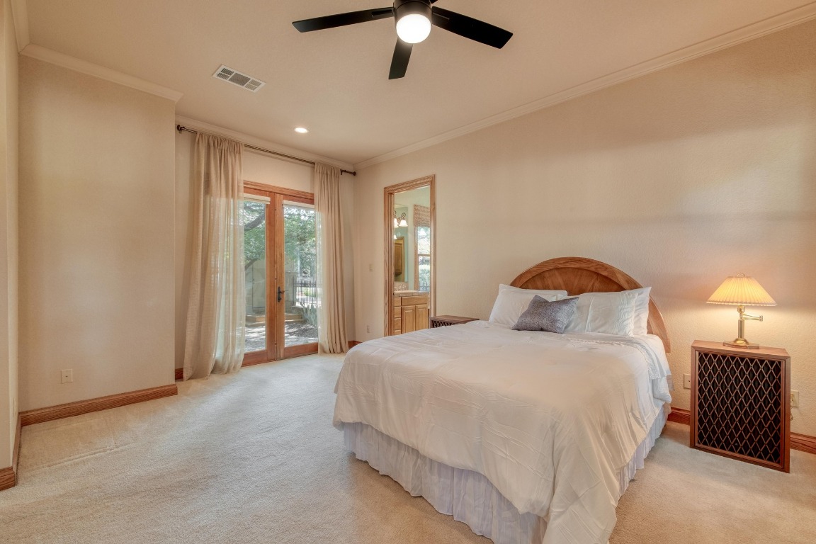 205 Flint Ridge Trail Georgetown, TX 78628 - Photo 19 of 40 a spacious bedroom with a bed and a chandelier