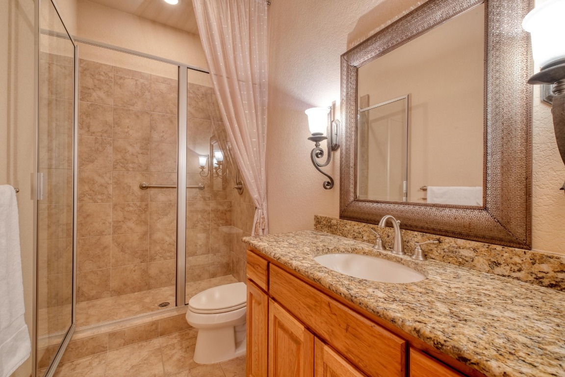 205 Flint Ridge Trail Georgetown, TX 78628 - Photo 31 of 40 a bathroom with a granite countertop sink toilet and shower