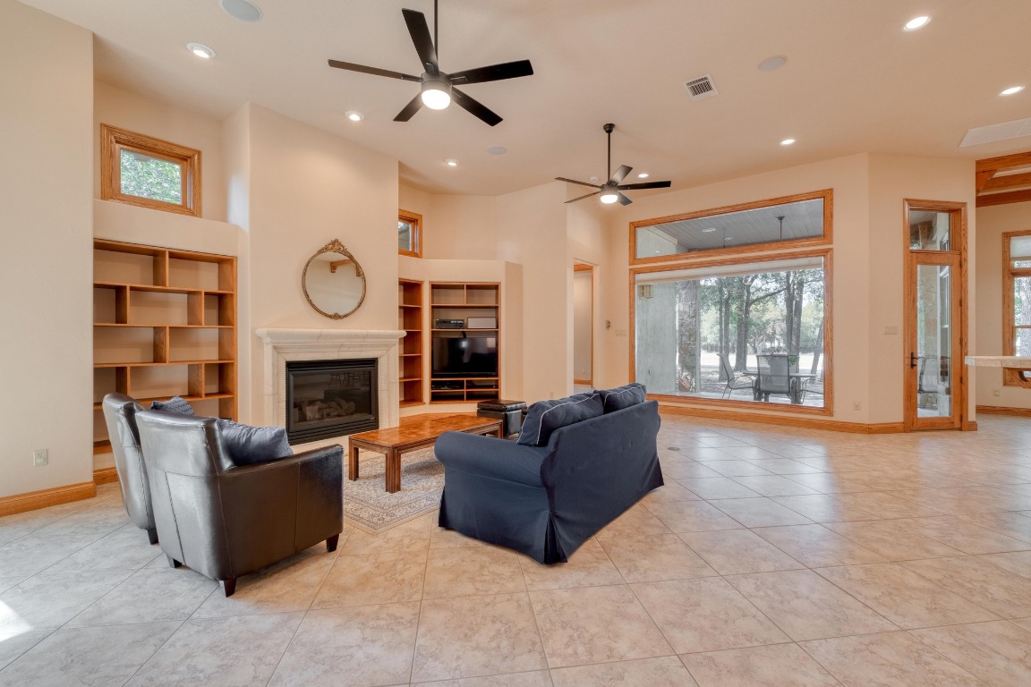 205 Flint Ridge Trail Georgetown, TX 78628 - Photo 10 of 40 a living room with furniture a clock and a fireplace