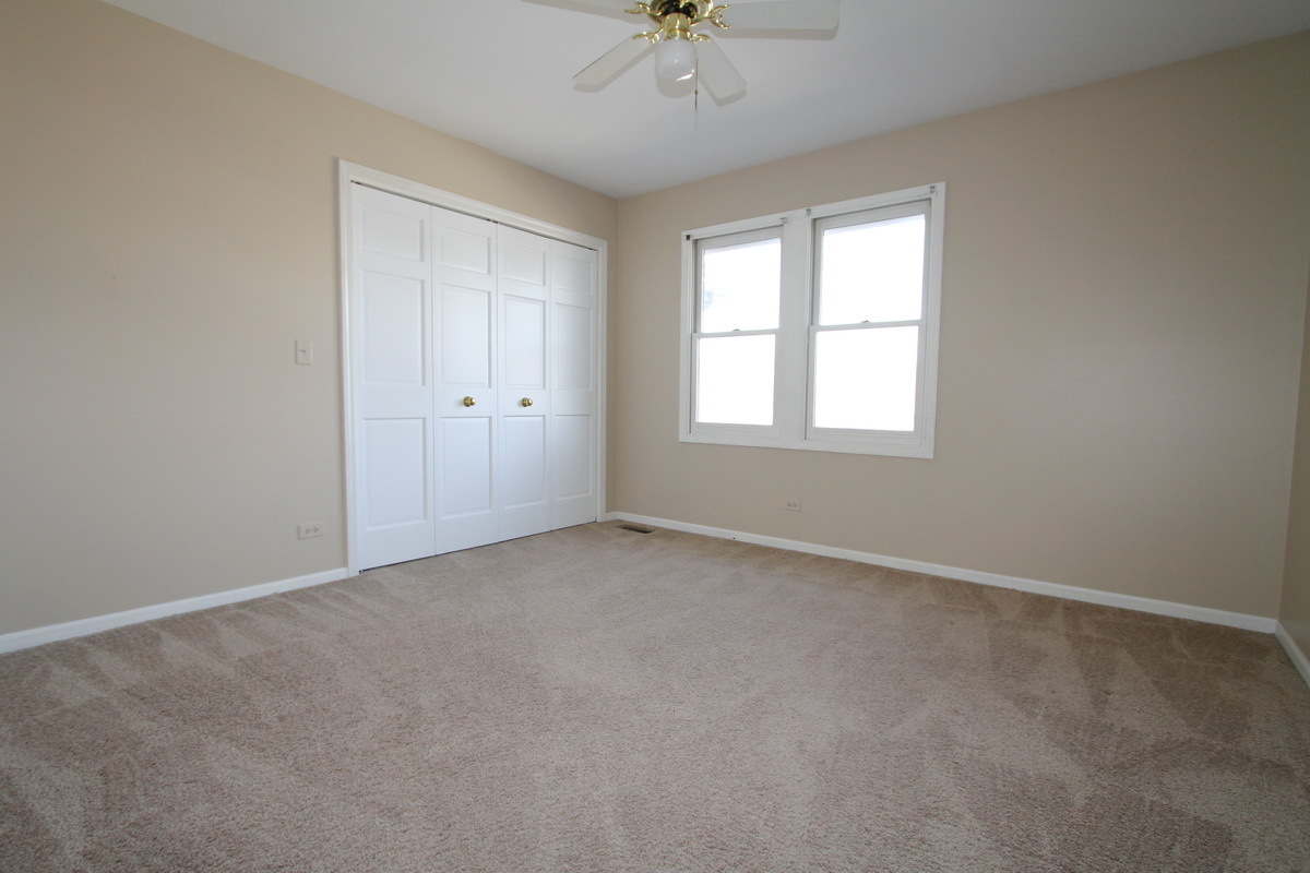 2165 Hidden Valley Drive Naperville, IL 60565 - Photo 17 of 29 an empty room with a window and a ceiling fan