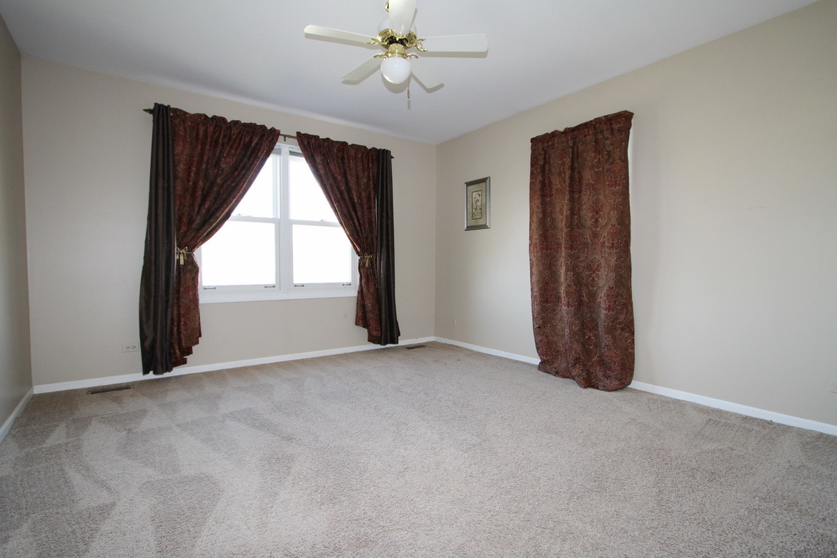 2165 Hidden Valley Drive Naperville, IL 60565 - Photo 19 of 29 an empty room with windows and fan