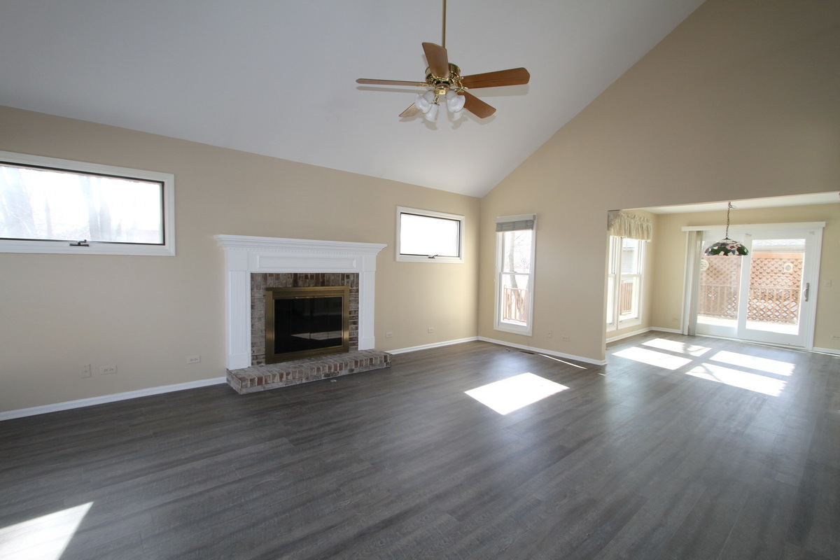 2165 Hidden Valley Drive Naperville, IL 60565 - Photo 5 of 29 a view of an empty room with wooden floor fireplace and a window