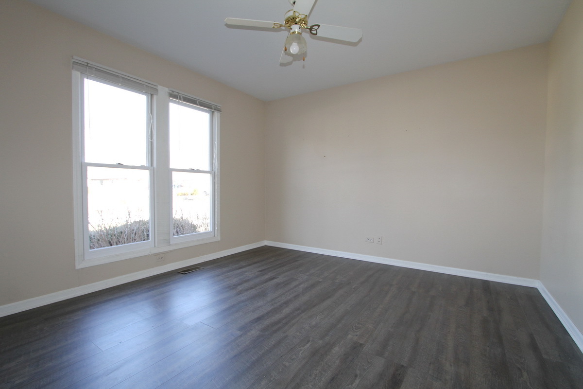 2165 Hidden Valley Drive Naperville, IL 60565 - Photo 7 of 29 an empty room with wooden floor windows and fan