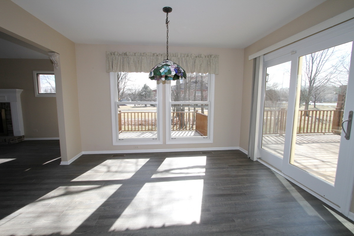 2165 Hidden Valley Drive Naperville, IL 60565 - Photo 8 of 29 a view of an empty room with wooden floor and a window