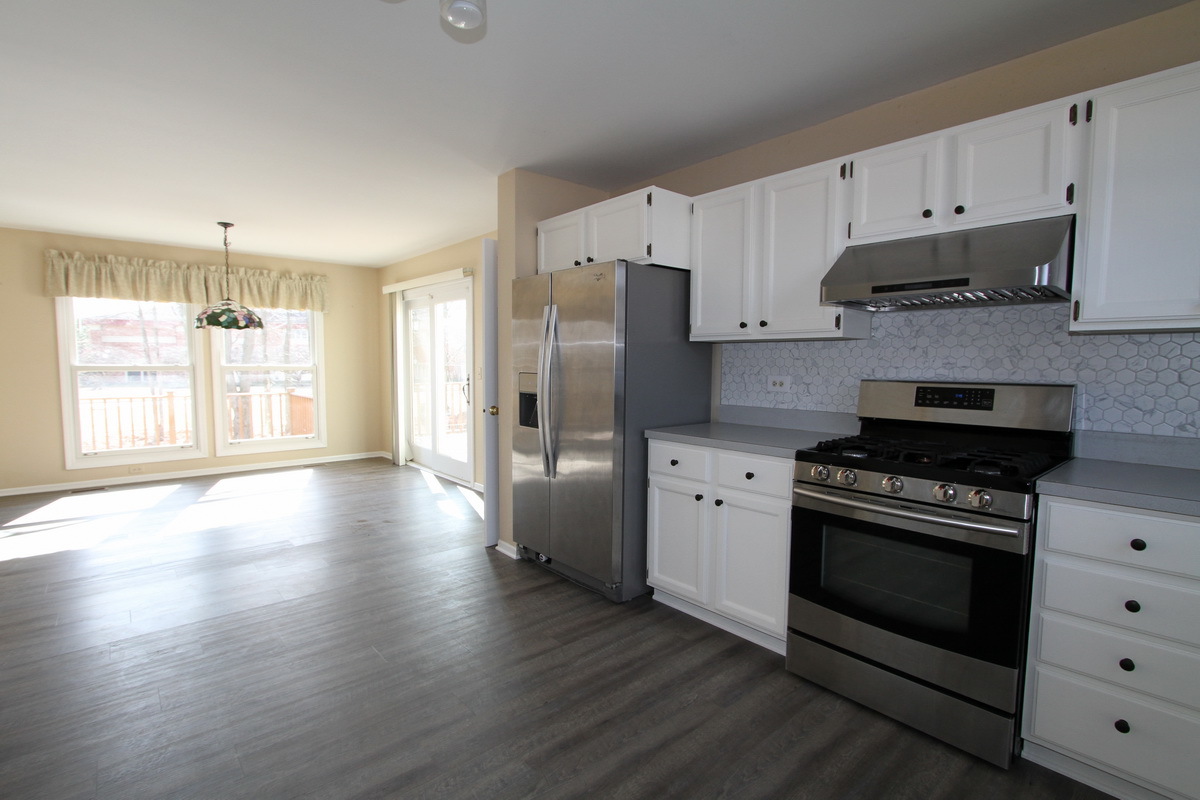 2165 Hidden Valley Drive Naperville, IL 60565 - Photo 10 of 29 a kitchen with stainless steel appliances a stove a sink and a refrigerator