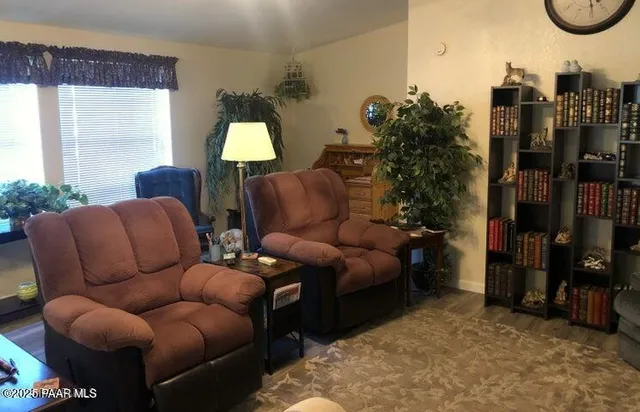 a living room with furniture a lamp and a large window
