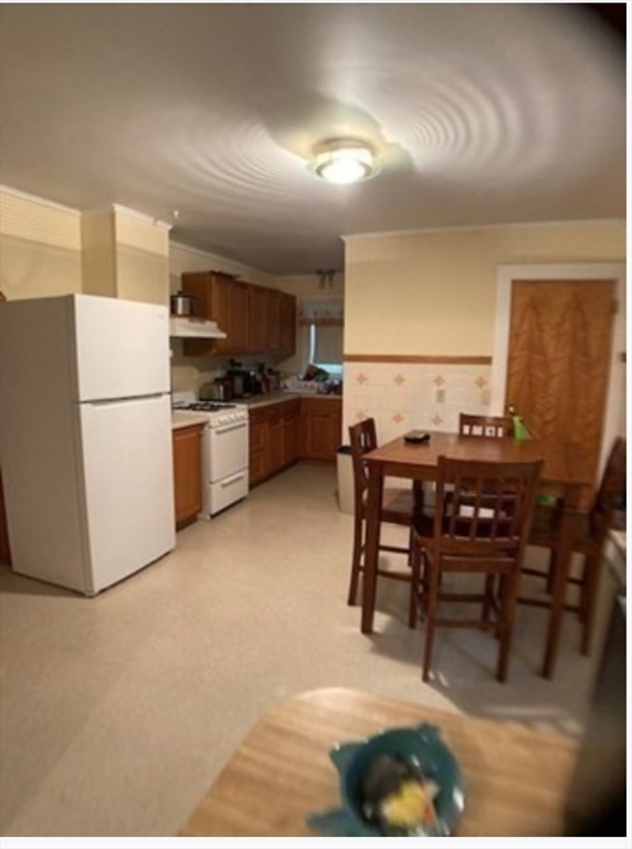 90 Massasoit Street, Unit 90 Waltham, MA 02453 - Photo 2 of 15 a kitchen with a table chairs stove and refrigerator