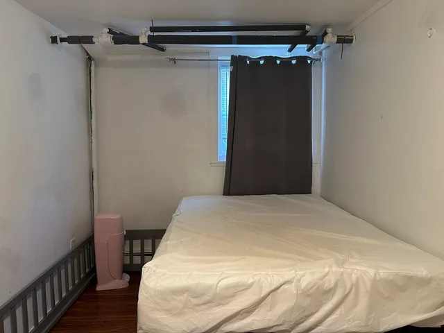 a bedroom with a bed and a wooden floor