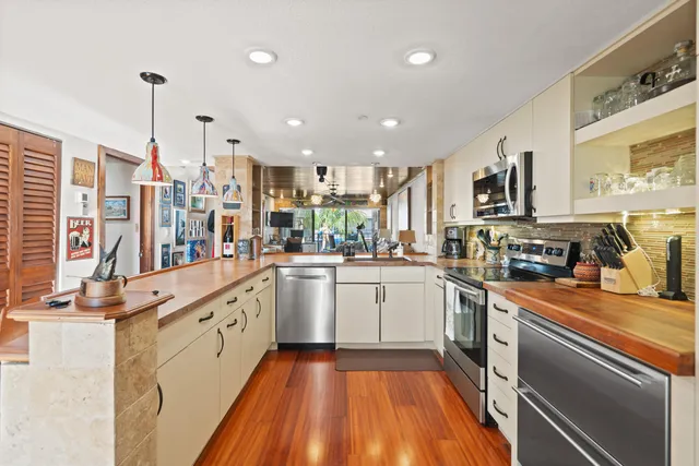 a kitchen with a sink window and stainless steel appliances