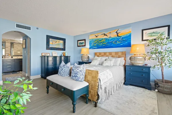 a bed room with furniture and a painting on the wall