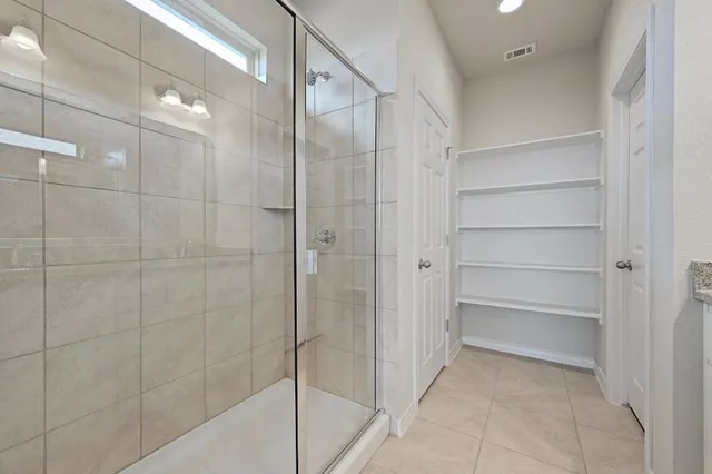 a bathroom with a shower and a glass door
