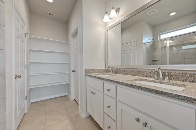 a bathroom with a granite countertop sink double and mirror