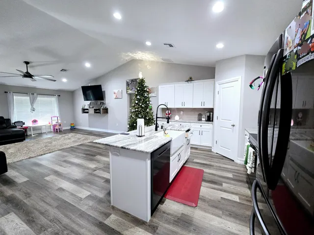 a kitchen with stainless steel appliances kitchen island granite countertop a sink stove and refrigerator
