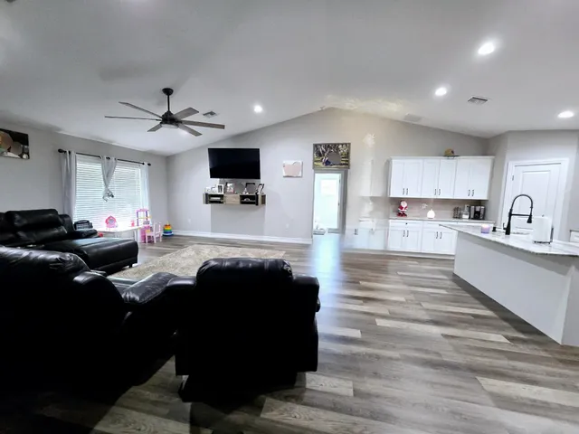 a living room with stainless steel appliances kitchen island granite countertop furniture and a view of kitchen