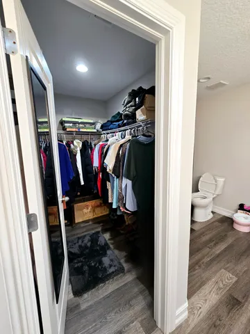 a view of walk in closet with clothes and shoes