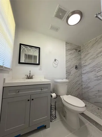 a bathroom with a toilet a sink and mirror