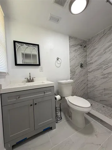 a bathroom with a toilet sink vanity and mirror