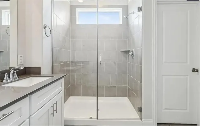 a bathroom with a shower sink and mirror