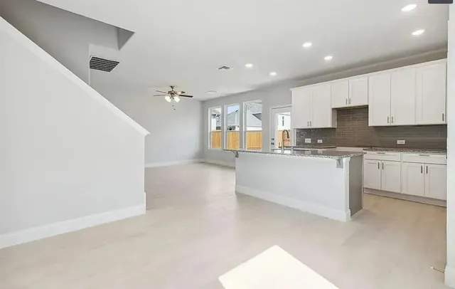a large white kitchen with a white stove top oven and white cabinets