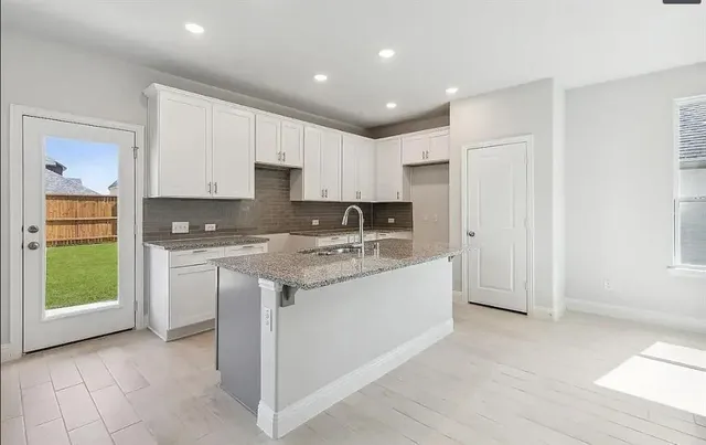 a kitchen with stainless steel appliances granite countertop a refrigerator and a stove