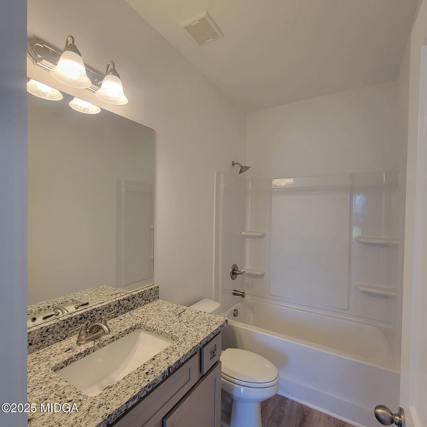 118 Bramblewood Way Perry, GA 31069 - Photo 14 of 27 a bathroom with a granite countertop sink a toilet and bathtub