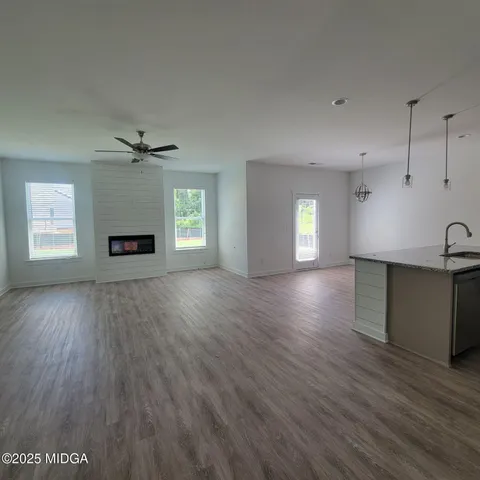 a view of empty room with wooden floor and window