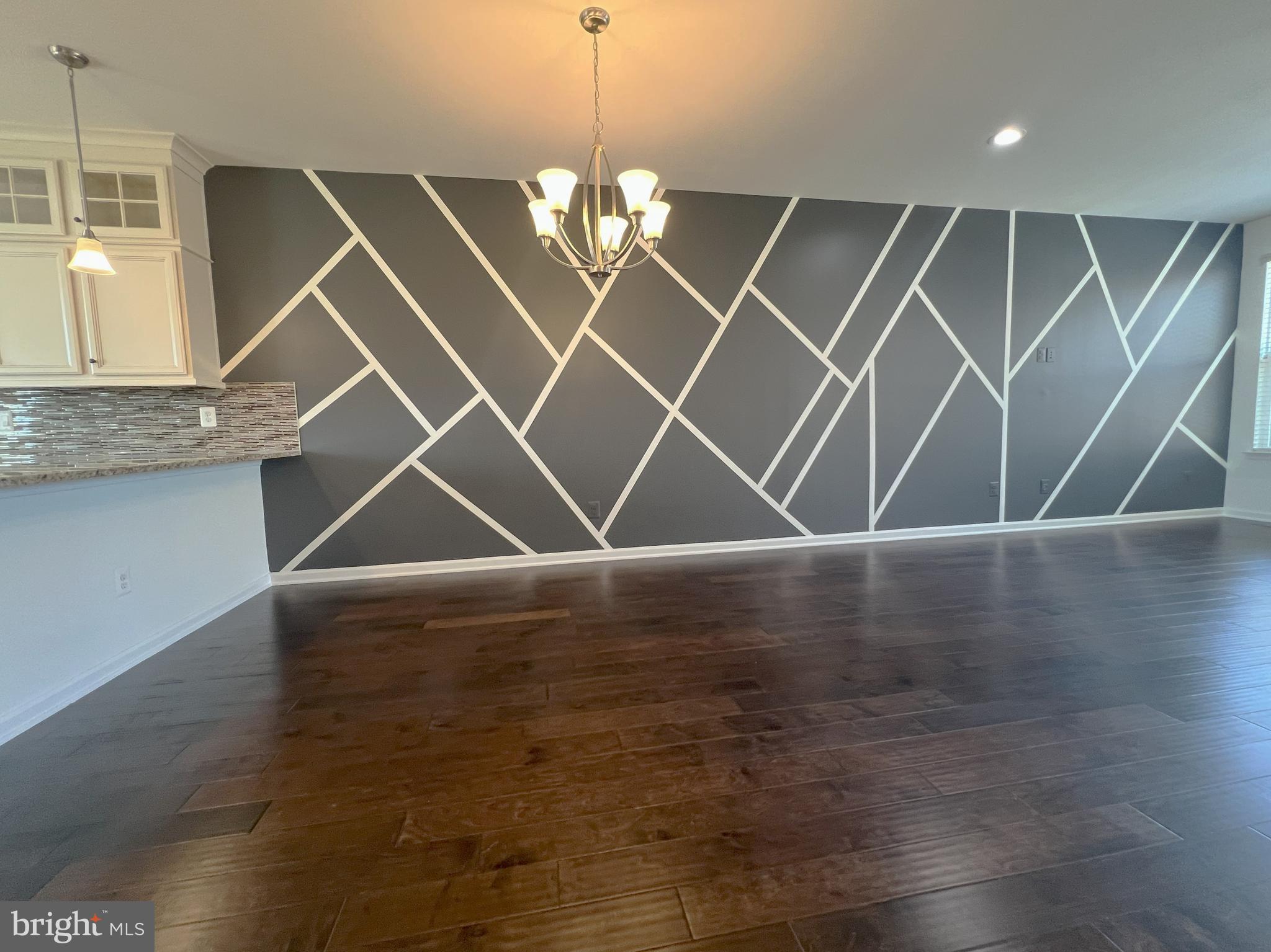 3092 Alan Shepard Street Herndon, VA 20171 - Photo 10 of 45 a room with wooden floor and a chandelier