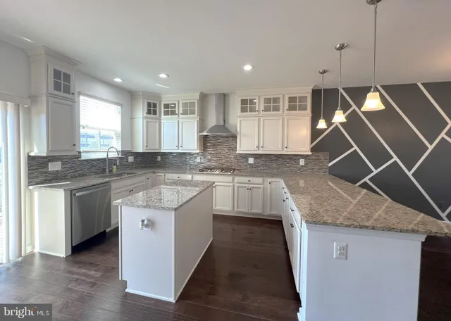 a kitchen with granite countertop a sink a counter space appliances and cabinets