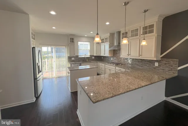 a kitchen with stainless steel appliances granite countertop a sink a oven and a large window