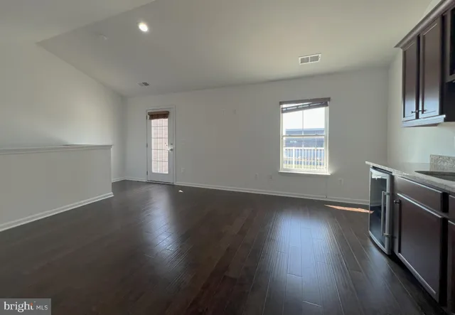 an empty room with wooden floors and windows