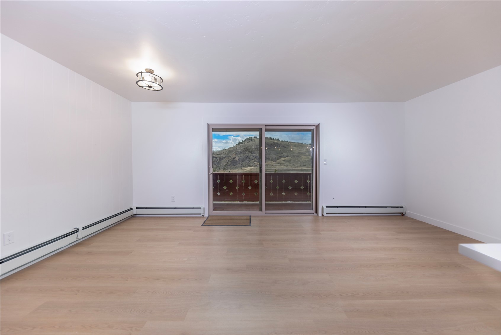 110 Evergreen Road, Unit 303 Dillon, CO 80435 - Photo 6 of 35 an empty room with chandelier fan and windows