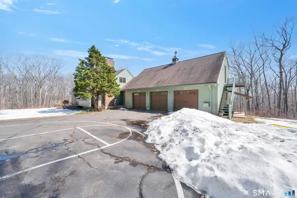 a front view of a house with a yard covered in snow