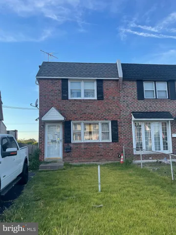 a brick house with a yard in front of it