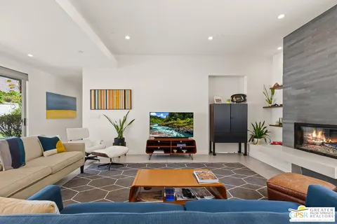 a living room with furniture kitchen view and a large window