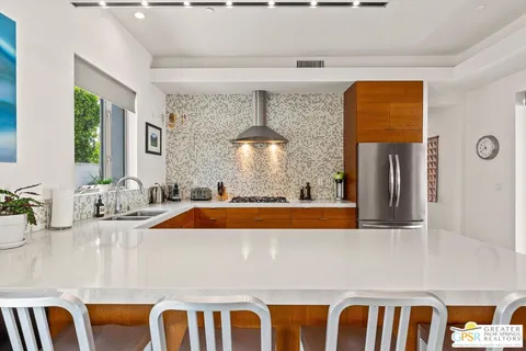 a view of living room with stainless steel appliances wooden floor and a window
