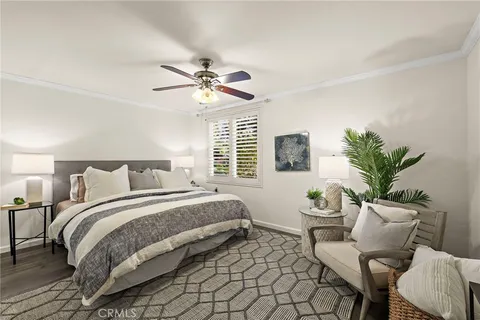 a spacious bedroom with a bed a couch and a potted plant on the dresser