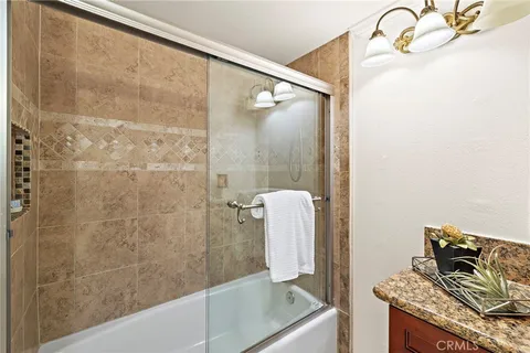 a bathroom with a granite countertop shower and a sink